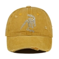 Close-up of mustard yellow distressed baseball cap with dinosaur skeleton embroidery. - Orange