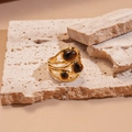 Detalle de anillo envolvente de acero dorado con piedras ojo de tigre sobre piedra - Anillo Envolvente de Varias Capas (Ojo de Tigre Marrón)