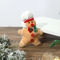 Detail of a handmade knitted gingerbread man ornament with a chef hat and bow tie - Flat Gingerbread Man Pendant Chef Hat