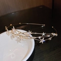 Macro shot of gold star-shaped ornaments with pearls and rhinestones on multi-layer headband - Gold Star