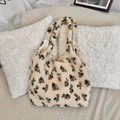 Gros plan sur un sac cabas en peluche douce avec motif floral et étiquette - Beige