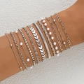 Set of 11 silver-toned stacked bracelets with pearls and rhinestones on woman's wrist - Airplane Chain Pearl 12-Piece Set / Silver