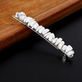 Dettaglio di un fermaglio per capelli con scaglie di cristallo bianco naturale su metallo - Howlite con clip d'argento