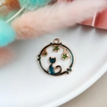 Golden starry cat pendant with dark blue enamel and green stars in hollow design - Cat in Circle