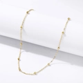 Detail of a gold beaded snake chain choker necklace draped on a white cylindrical display - Round Bead Chain Bracelet / Gold