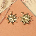 Retro golden sun charms with textured rays and concave back on leather surface - Antique Gold