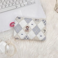 Detailed view of quilted makeup bag with teddy bear pattern and pink carrying loop - Diamond Bear