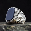 Macro detail of men's vintage silver ring with black gemstone and leaf engraving - US 7
