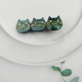 Detailed close-up of dark green marble pattern acetate hair clip with triple cat design - Dark Green