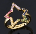 Bague étoile dorée avec zircons colorés sertis sur une surface réfléchissante - Pentagramme