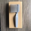 Grey plastic barber fade comb with precise spacing slots on a simple wooden background - Model B Grey 1Pc Kraft Box