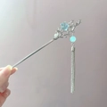Detailansicht eines silbernen Haarstabs mit blauem Sternanhänger und Metallquasten - Stern Quaste