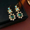 Makro-Detail von Vintage-Goldohrringen mit blauem Stern und grünen Zirkonia-Steinen - Vintage Blumenohrringe / Silbernadel - Blau (Vergoldet)