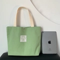 Light green canvas tote bag with a cute puppy patch and snap closure shown with iPad - Emerald Green