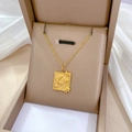 Detail van gouden hemelse hanger met maan- en zonmotieven in een luxe geschenkdoos - Titaniumstaal / Goud