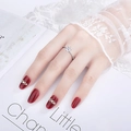 Detailed view of a six-claw heart ring with side stones on a model's hand - J249 (White Gold)