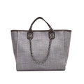 Detalle de bolso saco tejido gris con asas de cuero marrón y correa de cadena plateada - Gris