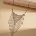 Detalle del collar de malla triangular plateada con flecos largos colgando de un soporte - Plateado
