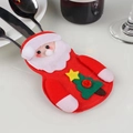 Detail view of Santa Claus felt cutlery holder with embroidered tree on a white table - Santa Claus