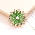 Élégante broche fleur dorée avec cristaux verts et centre perle blanche sur plateau - Vert