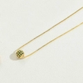Minimalist golden necklace featuring a hollow spherical pendant with green zircon gemstones - Green