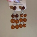 Détail de boucles d'oreilles en perles d'ambre avec base argentée et étiquette vintage - Style Grappe de Perles (Tige Argent-Café-Rond)