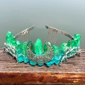 Detail view of green crystal crown with silver moon and branch accents on wood - Green Blue
