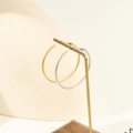 Macro shot of large textured gold and silver hoop earrings with a twisted wire design - 40mm / Steel