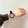 Minimalist quartz watch with white dial and black leather strap worn on wrist - Large Size - Numeric White Dial