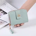 Close-up of mint green quilted wallet with gold ring buckle and tassel zipper detail - Light Green