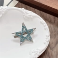 Detailed macro view of a Y2K blue rhinestone star hair clip on a vintage tray - Hollow Star / Green