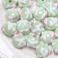 Macro view of light green hand-painted beads with floral patterns and small rhinestones - 18mm / Green Bead with White Pattern and Rhinestone
