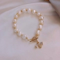 Elegant pearl bracelet with golden bee charm and OT toggle clasp on silk background - Bee Pearl T-Buckle Bracelet