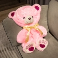 Plush pink teddy bear with gold ribbon and heart paws sitting on a gray cushion - 35cm (Skin/No Filling) / Pink