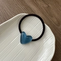 Detailed shot of a blue heart resin charm on a black elastic hair tie in a white ceramic dish - Jelly Heart Hair Tie-Blue