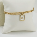 Primer plano de la pulsera dorada de doble capa con colgante de letra K y nácar blanco - Letra K
