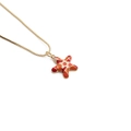 Macro shot of colorful enamel starfish pendant with gold outlines on a box chain - Starfish / Colorful