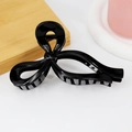 Detail of glossy black bow hair claw clip showing a polished finish and secure teeth - Glossy Black