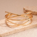 Detail of a layered geometric cross open cuff bracelet in polished gold finish on stone - Gold