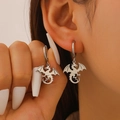 Gros plan de boucles d'oreilles dragon en argent avec ailes détaillées sur un modèle - Couleur Acier (1946)