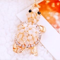 Macro shot of golden turtle keychain with moonstone beads and sparkling rhinestones - White Fortune Turtle