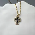 Detailed close-up of gold cross pendant with black onyx and white cubic zirconia - Black Zirconia Cross