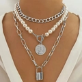 Close-up of layered baroque pearl necklace with silver coin and padlock charms on a model - 20 Silver Tone Lock Necklace Set
