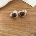 Macro shot of heart-shaped tweed earrings in brown and beige tones on wooden surface - Off White