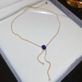 Dettaglio della collana con nappe dorate e ciondolo quadrato con gemma blu scuro - Collana Oro Con Pietra Blu