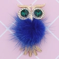Detailed view of an owl charm with blue faux fur, green crystal eyes and gold alloy frame - Owl (D2166) / Sapphire Blue