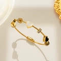 Golden titanium steel twist wire bracelet with black and white heart charms and zircons - 134 Heart Bangle / Gold