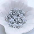 Dettaglio macro di perle di fiori di prugno in ceramica azzurra per gioielli fai-da-te - Grigio Argento