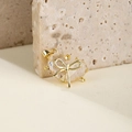 Golden double zircon heart bow pendant on natural beige stone texture background - White