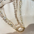 Detail of double-layer necklace featuring white pearls, crystals and a gold setting - Gold